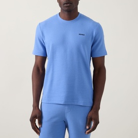 Model wearing Hugo Austin Pyjama T-Shirt in Bright Blue, crew neck, short sleeves, waffle-knit texture, chest logo, styled with matching lounge