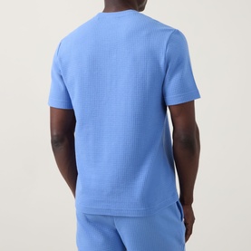 Model wearing Hugo Austin Pyjama T-Shirt in Bright Blue, waffle-knit texture, crew neck, short sleeves, styled with matching joggers.