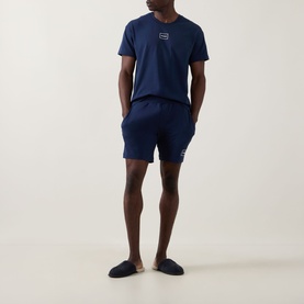 Model wearing Hugo Laze Logo Lounge Shorts in navy, paired with a matching navy logo T-shirt and navy slippers.