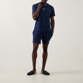 Model wearing Hugo Laze Logo Lounge T-Shirt in navy, styled with matching navy shorts and slip-on slippers.