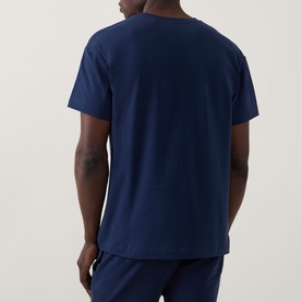 Model wearing Hugo Laze Logo Lounge T-Shirt in navy, rear view showing crew neck, dropped shoulders and short sleeves, styled with navy joggers.