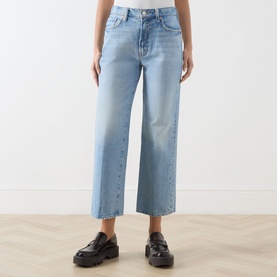 Model wearing Mother Straight Jeans in light blue denim, wide-leg cropped cut, styled with black chunky loafers