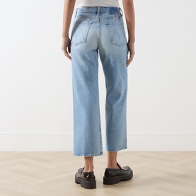 Model wearing Mother straight-leg jeans in light blue denim, rear view, styled with black chunky loafers