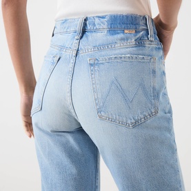 Model wearing Mother straight jeans in Reelin In The Fun light blue wash, rear view showing M-stitched back pockets, 100% cotton denim