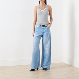 Model wearing Mother Wide Leg jeans in light blue with a grey ribbed vest top and black heeled mules.