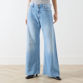 Model wearing Mother Wide Leg Jeans in light blue, high-rise waist, relaxed wide-leg fit, styled with black heeled boots.