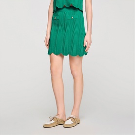 Model wearing Sandro Scallop Trim Knitted Skirt in emerald green, styled with matching knit top and beige loafers