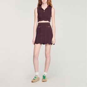 Model wearing Sandro Wave Cropped Knit Top in brown with buttoned polo collar, styled with matching skirt and platform sandals.
