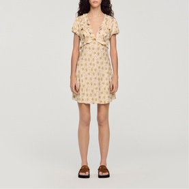 Model wearing Sandro Floral Ruffle Mini Dress in light pink with floral print, V-neckline, ruffled top, and short sleeves, styled with brown sandals
