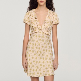 Model wearing Sandro Floral Ruffle Mini Dress in light pink with green floral print, V-neckline, ruffled bust, and short sleeves