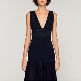 Model wearing Sandro Embroidered Hybrid Dress in black, featuring deep V-neckline, lace trim detail, and tiered chiffon skirt.