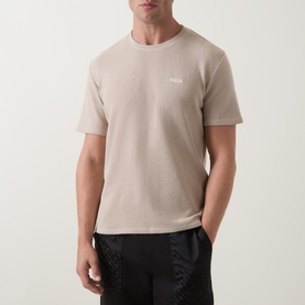 Model wearing Hugo Boss Waffle Texture Lounge T-Shirt in light beige with crew neck and contrast chest logo, styled with black trousers