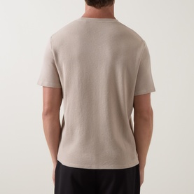 Model wearing Hugo Boss Waffle Texture Lounge T-Shirt in Light Beige, rear view, crew neck, short sleeves, paired with black trousers