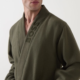 Model wearing Hugo Boss Logo Waffle Robe in green, showing waffle texture, shawl lapel, and tonal BOSS logo embroidery at collar.