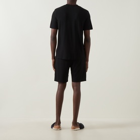 Model wearing Hugo Boss Piqu&eacute; Shorts Pyjama Set in black, showing rear view of short-sleeve T-shirt and above-the-knee shorts