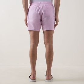 Model wearing Hugo Boss Iconic Logo Swim Shorts in Bright Pink, elasticated waistband with drawstring, rear view, styled with dark canvas shoes.