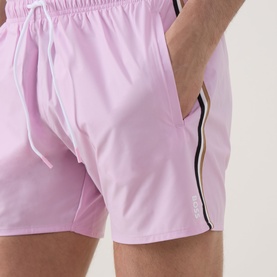 Model wearing Hugo Boss Iconic Logo Swim Shorts in Bright Pink with elasticated waistband, drawstring, side pocket, and stripe leg detailing.