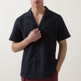 Model wearing Hugo Boss black short-sleeve camp collar shirt with chest pockets, styled with burgundy trousers