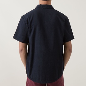 Model wearing Hugo Boss black short-sleeve shirt, rear view, styled with burgundy trousers
