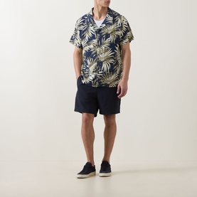 Model wearing Hugo Boss dark beige palm print short-sleeve shirt, styled with navy shorts and navy trainers