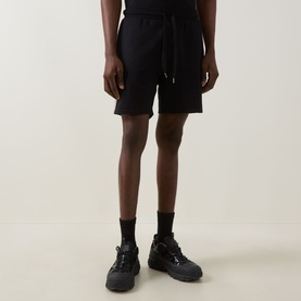 Model wearing Hugo Boss black cotton shorts with drawstring waist, styled with chunky black trainers