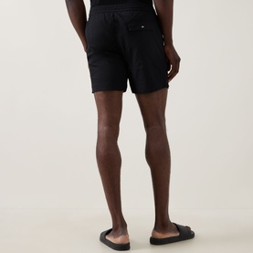 Model wearing Hugo Boss Logo Seersucker Swim Shorts in black, rear view, showing rear flap pocket and elasticated waist, styled with black slides.