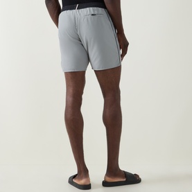 Model wearing Hugo Boss Starfish Logo Swim Shorts in grey, back view, showing contrast side piping and elasticated waist, styled with black slides.