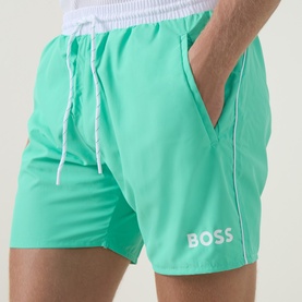 Model wearing Hugo Boss Bright Green swim shorts with white drawstring, contrast piping, and logo print on leg