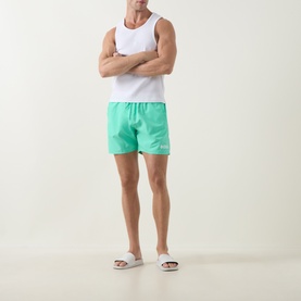 Model wearing Hugo Boss Bright Green swim shorts with elasticated waist, styled with white vest and white sliders.