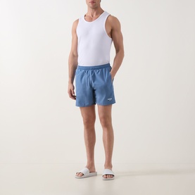 Model wearing Hugo Boss Swordfish Logo Swim Shorts in light blue with white vest and slides