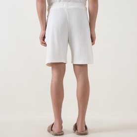 Model wearing Hugo Boss Structure Logo Textured Lounge Shorts in Natural, back view, styled with tan sandals