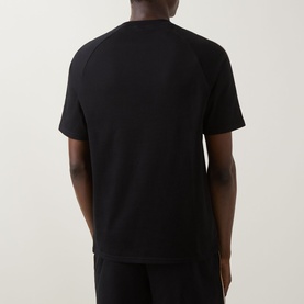 Model wearing Hugo Boss black cotton loungewear T-shirt, rear view, with matching black trousers.