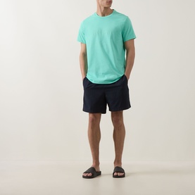 Model wearing Hugo Boss Bright Green cotton T-shirt with navy swim shorts and brown slider sandals.