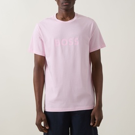 Model wearing Hugo Boss Big Logo T-Shirt in Bright Pink, crew neck with tonal BOSS chest lettering, paired with navy trousers.