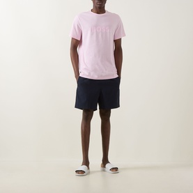 Model wearing Hugo Boss Big Logo T-Shirt in Bright Pink with navy shorts and white slides