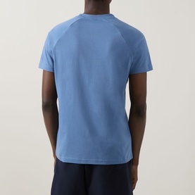 Model wearing Hugo Boss light pastel blue raglan-sleeve T-shirt, back view, styled with navy shorts.