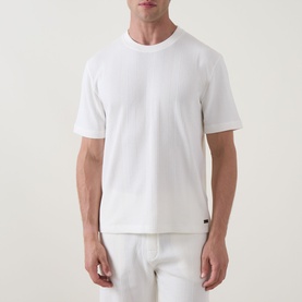 Model wearing Hugo Boss Structure Logo Textured Lounge T-Shirt in Natural, round neck, short sleeves, styled with matching lounge shorts.