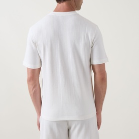 Model wearing Hugo Boss Structure Logo Textured Lounge T-Shirt in Natural, back view, short sleeves, straight hemline, styled with matching lounge