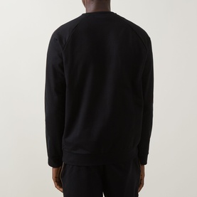Model wearing Hugo Boss black cotton crew neck sweatshirt, back view, styled with matching black joggers.