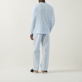 Model wearing Calvin Klein Logo Check Print Pyjama Set in ballad blue; back view showing long-sleeve top and check print straight-leg bottoms.