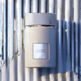 TOM FORD Soleil Neige Eau de Parfum 50ml, ribbed ivory flacon with silver cap, displayed against corrugated metal wall