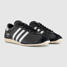 Adidas trainers in core black with silver metallic three stripes, lace-up fastening, and cream rubber cupsole