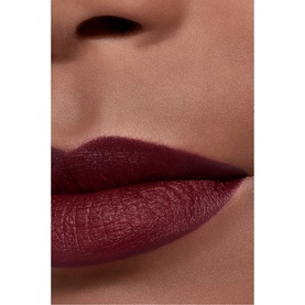 Model wearing CHANEL Rouge Allure Velvet Luminous Matte Lip Colour in a deep burgundy-plum shade, shown in a close-up lip shot