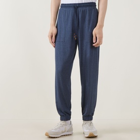 Model wearing Paul Smith Access Harry Lounge Sweatpants in blue, slim-leg with cuffed ankles, drawstring waist and patch pockets, styled with white