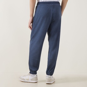 Model wearing Paul Smith Access Harry Lounge Sweatpants in blue, slim-leg with cuffed ankles and drawstring waist, styled with white trainers.