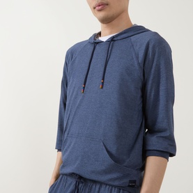 Model wearing Paul Smith Access blue modal blend hoodie top with kangaroo pocket and brown-tipped drawstring, paired with matching lounge shorts.