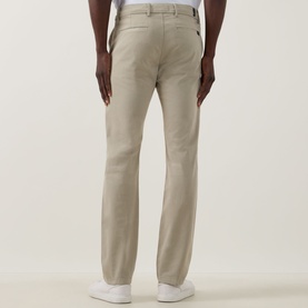 Model wearing Seven Jeans Slimmy Stretch Slim Leg Jeans in Rawhide, rear view showing belt loops and tonal stitching, styled with white trainers.