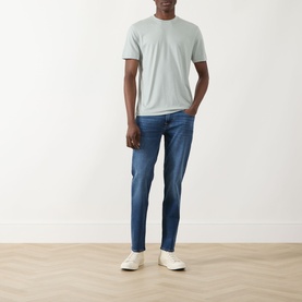 Model wearing Seven Jeans Dusty Blue Crew Neck T-Shirt with mid-blue slim jeans and white trainers.