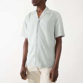 Model wearing Seven Jeans Dusty Blue lyocell reg shirt with camp collar and short sleeves, styled with cream trousers