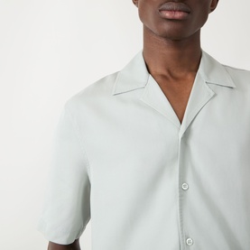 Model wearing Seven Jeans Dusty Blue lyocell reg shirt with camp collar and short sleeves, close-up chest detail